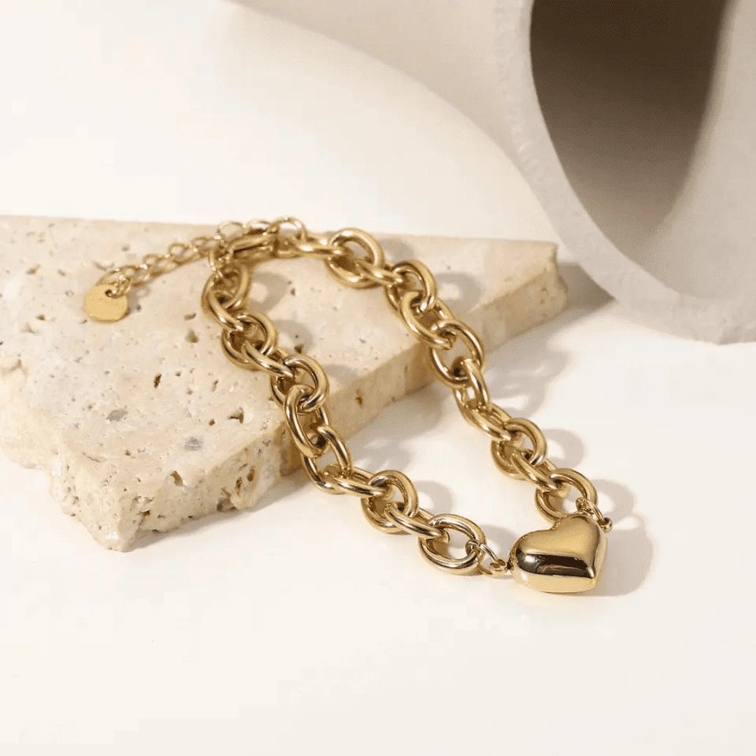 Gold link chain bracelet with heart charm, symbolizing love and elegance