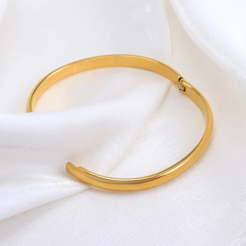 The radiant gold bangle that shines like the sun!   Crafted with exquisite detail and plated in lustrous 18K gold, our Helios bangle exudes timeless elegance.