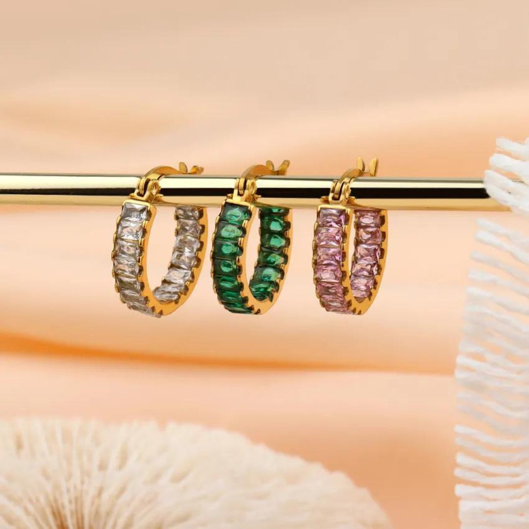 picture of three different zircon and gold earrings.  Green, pink and white