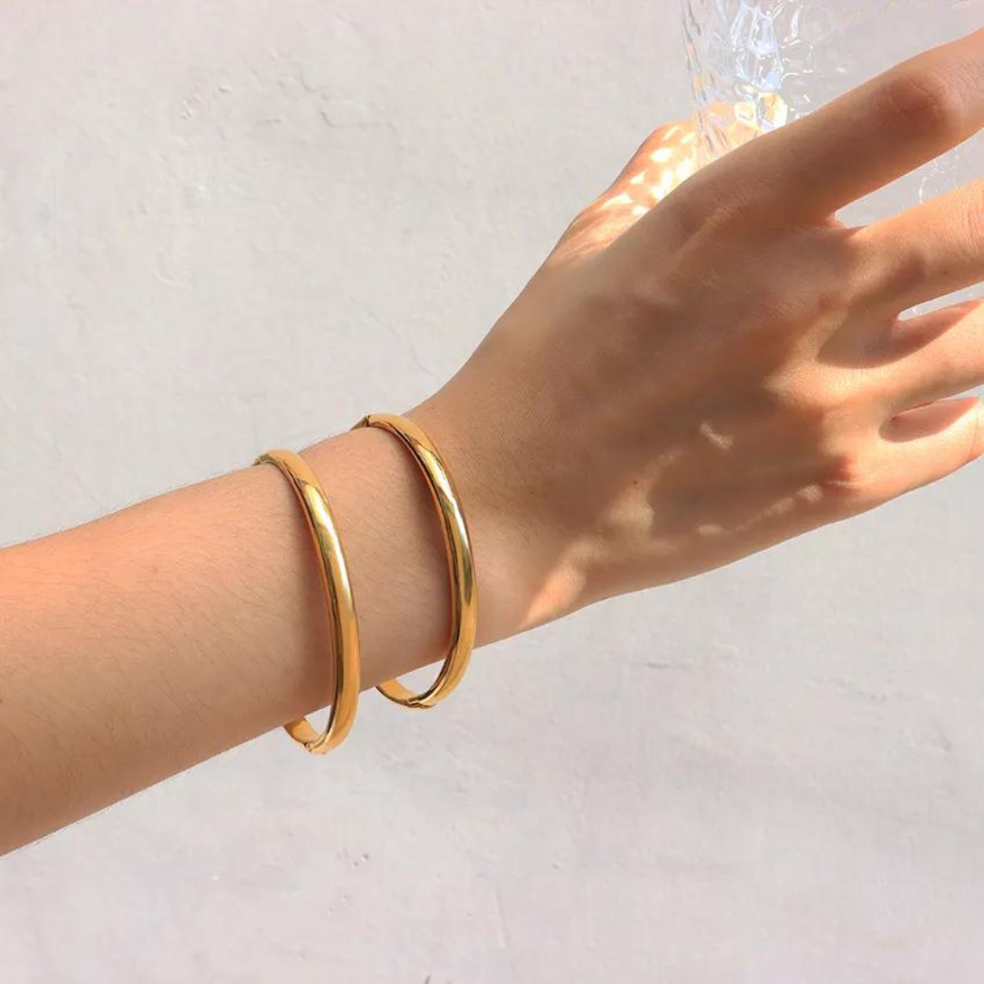 The radiant gold bangle that shines like the sun!   Crafted with exquisite detail and plated in lustrous 18K gold, our Helios bangle exudes timeless elegance.