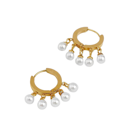 The combination of pearls and gold  in a playful hoop shape make them the perfect complement to any outfit, from a beach day to a night out !