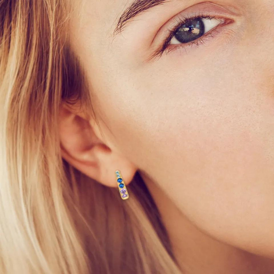 Pretty blonde girl wearing colourful zircons stones Celestial Gold Huggie Earrings